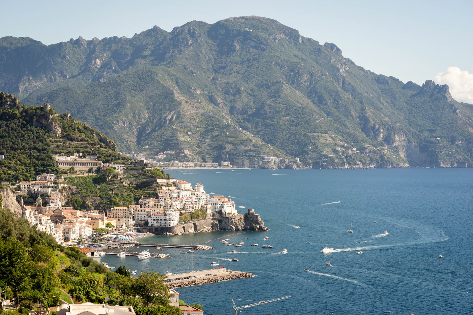 Newlyweds sharing a kiss with Amalfi in the background